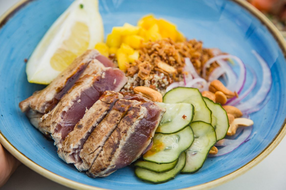 Grilled tuna steak with quinoa salad, mixing traditional with modern trendy ingredients